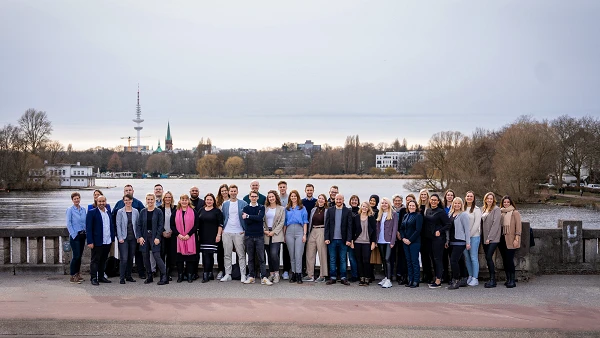 Gruppenfoto des Teams von Mertens Schabow vor der Alster in Hamburg